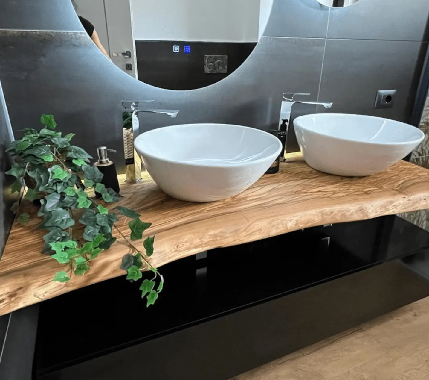 Luxe massief eiken wastafelbladen met zwarte designwaskom en gouden kraan, gecombineerd met een ronde LED-spiegel van SaniSupreme